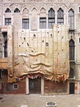 Grande tapeçaria de metal pendurada sobre a fachada de um palácio veneziano
