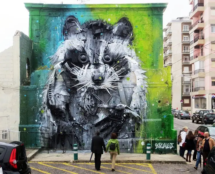 Guaxinim gigante de Bordalo II em relevo numa parede, feito de resíduos
