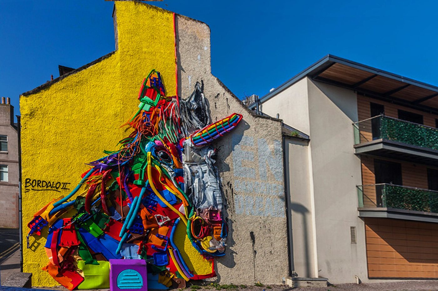 Animal em relevo muito colorido numa parede amarela de uma casa