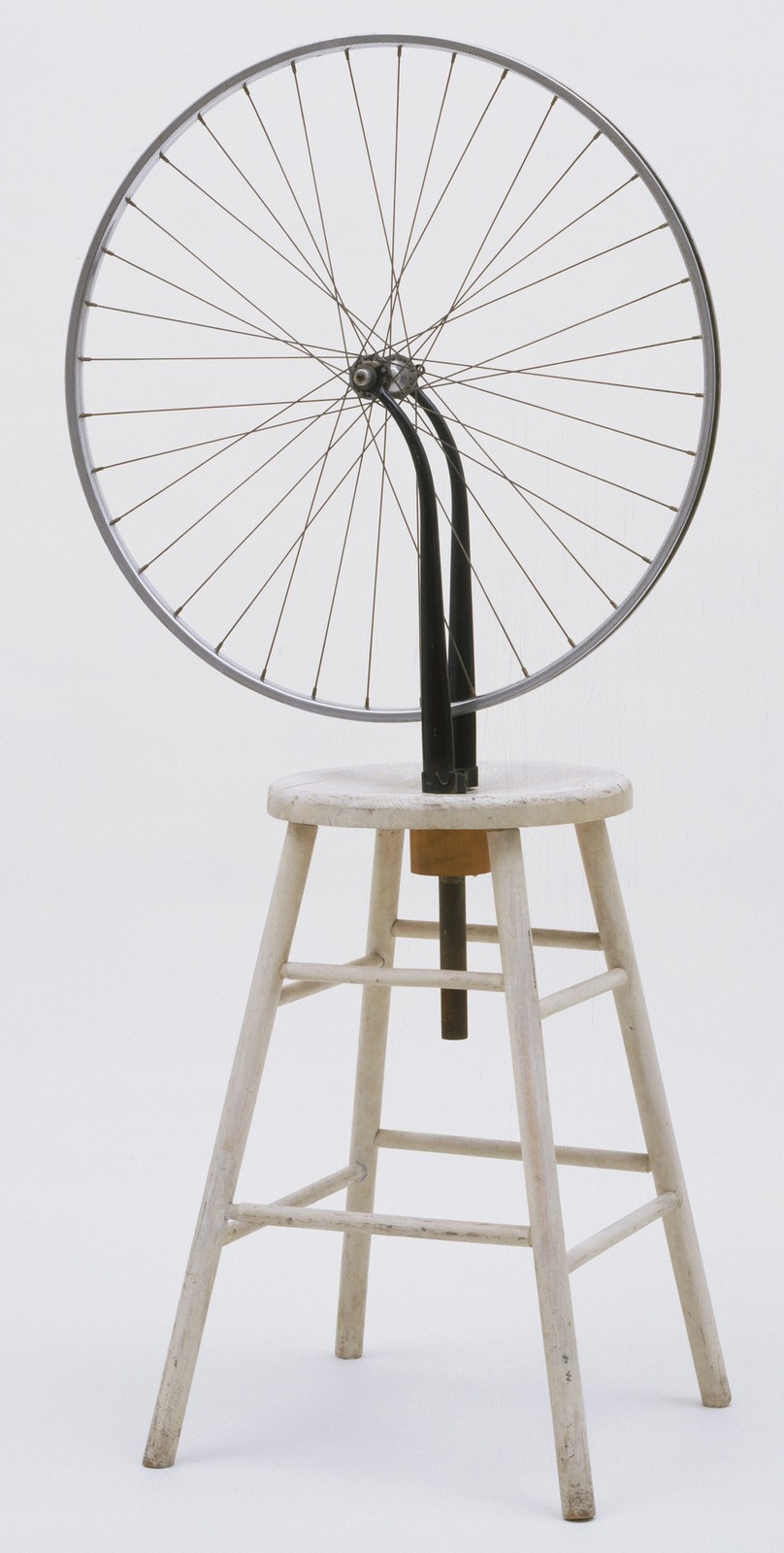 Roda de bicicleta montada de cabeça para baixo sobre um banco de madeira