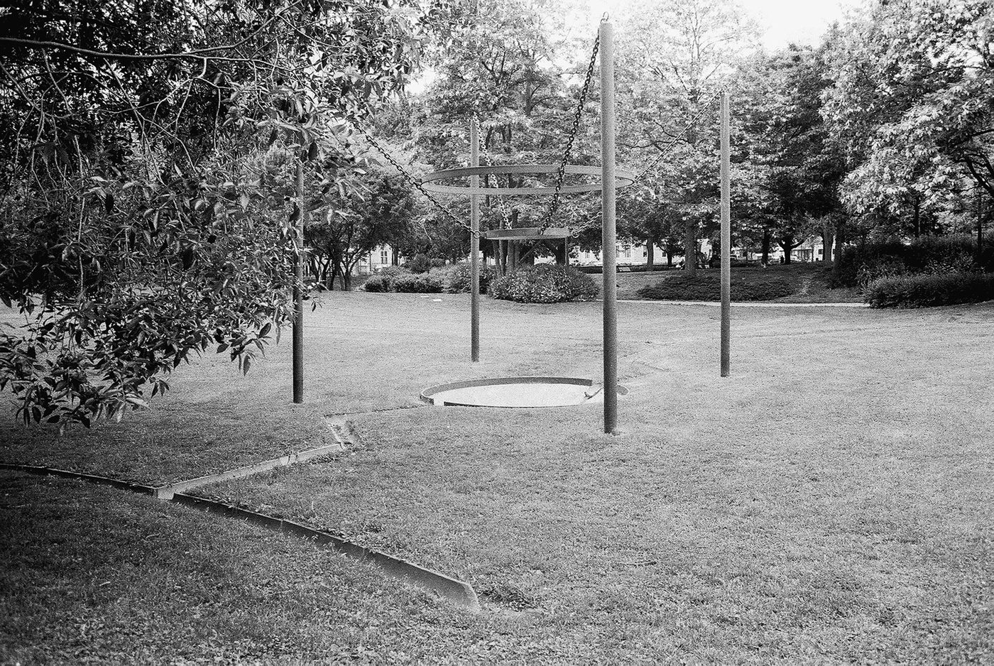 Obra num parque com uma bacia circular e estruturas metálicas, a preto e branco
